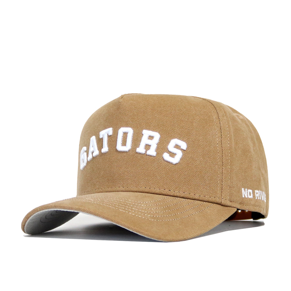 The Florida Rustic Hat by No Rivals is a tan cotton canvas cap with "GATORS" embroidered in white on the front and "NO RIV" stitched on the brim, designed with a structured fit for comfort.