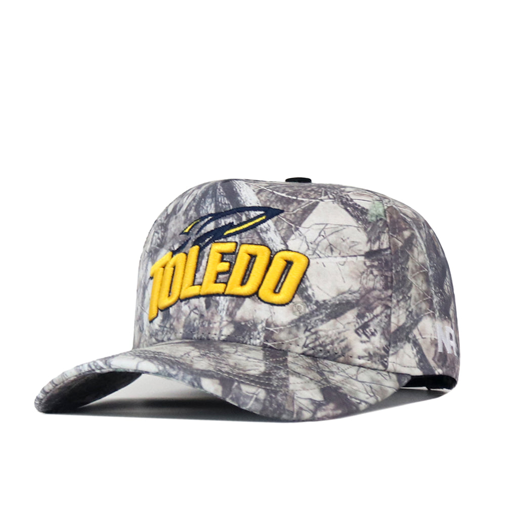 The No Rivals Toledo Outland Hat is a structured fit cap featuring a camouflage print, with “Toledo” embroidered in yellow and a blue and yellow logo above the text. It includes an adjustable snap back closure for a comfortable, customizable fit.