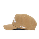 The West Virginia Rustic Hat by No Rivals is a tan cotton canvas cap with white "NO RIVALS" embroidery on the side and partial front text. Shown in left-profile, this adjustable hat is set against a white background.