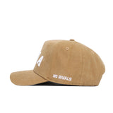 The Iowa Rustic Hat by No Rivals is a tan cotton canvas baseball cap with "NO RIVALS" white embroidery on the side and a classic snapback for adjustable fit, shown in side profile against a white background.