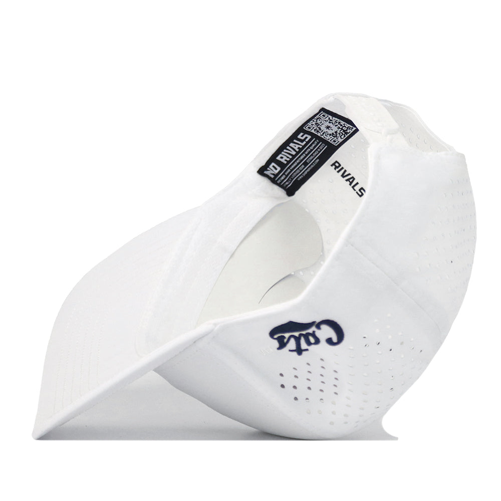 A white Montana State Football Hat by No Rivals, featuring perforated holes, an embroidered navy “C” with “RIVALS” text on the front, and visible tags inside the brim, is displayed on its side against a white background—perfect for your next gameday look.