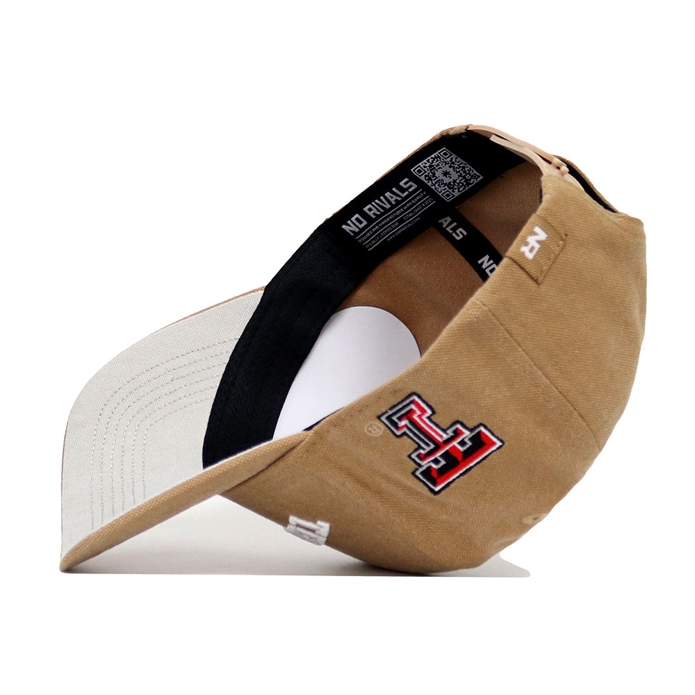The Texas Tech Rustic Hat by No Rivals is a tan cotton canvas cap with a white brim, red and black TT logo embroidery on the side, and “NO RIVALS” in white text on the inside band. Shown here positioned on its side.