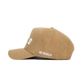 The Western Kentucky Rustic Hat by No Rivals is a tan cotton canvas hat with white "NO RIVALS" embroidery near the brim, partial front lettering, and a classic structured fit, shown from a side view.