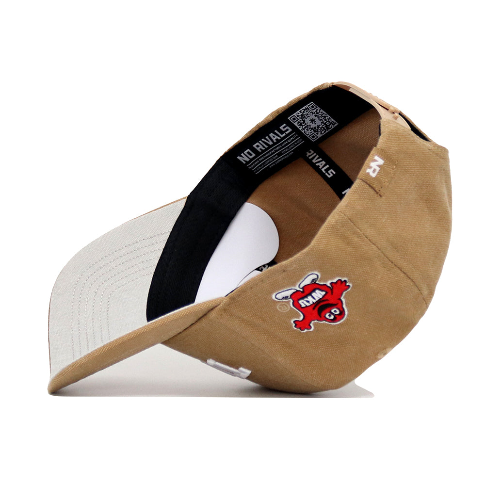The Western Kentucky Rustic Hat by No Rivals is shown upside down, revealing its inner band and tags. This tan and white cotton canvas cap features an embroidered red cartoon character with a white outline and black details on the side.