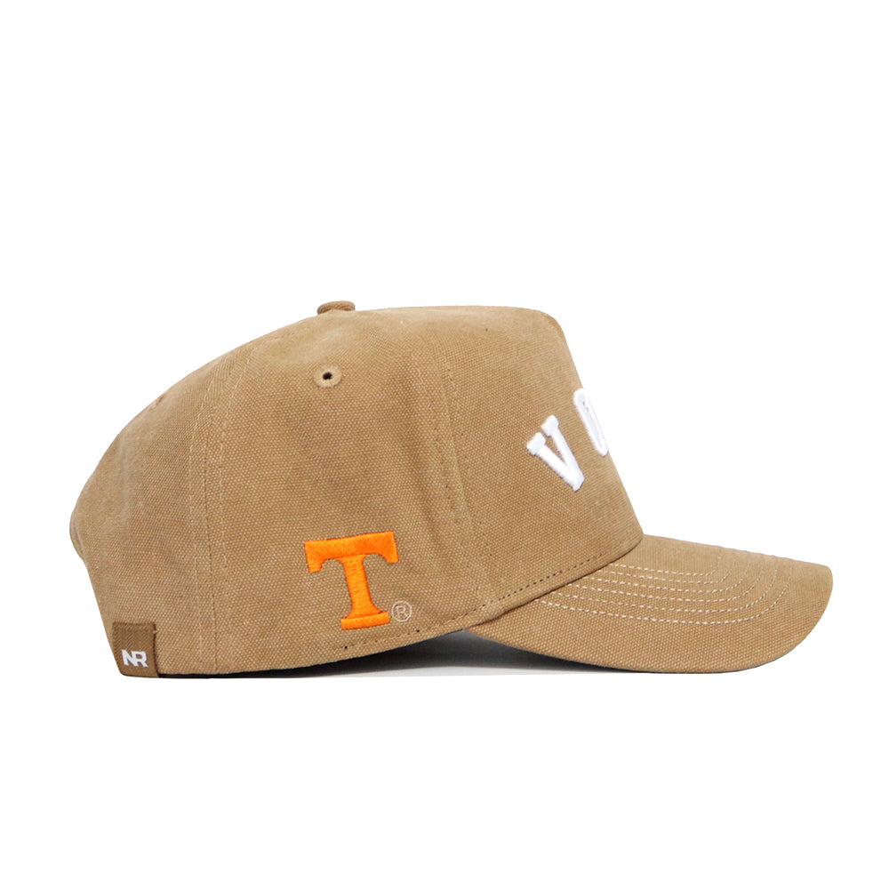 The Tennessee Rustic Hat by No Rivals is a tan cotton canvas baseball cap with white VOLS on the front, an orange T logo® on the side, white stitching accents, a curved brim, structured fit, and adjustable snapback closure.