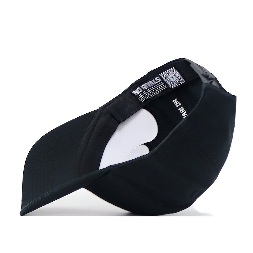 The No Rivals LSU Outlaw Hat - Black is flipped upside down, revealing its interior with a white paper insert and visible tags. Perfect for completing your next Gameday Fit, this cap rests on a white surface.
