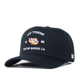 Introducing the LSU Outlaw Hat - Black by No Rivals: This snapback baseball cap features a striking embroidered tiger logo, “1860,” and “Baton Rouge, LA” in bold white and purple on the front. The iconic NR letters are stitched in white on the side—making it the perfect finishing touch for your next Gameday fit.