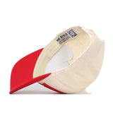 The No Rivals SMU Mustangs Stride Hat is shown inside out, highlighting the inner tags, sweatband, and stitching. Featuring a red visor and beige crown, this officially licensed snapback cap displays detailed embroidered SMU Mustangs logos for an authentic look.