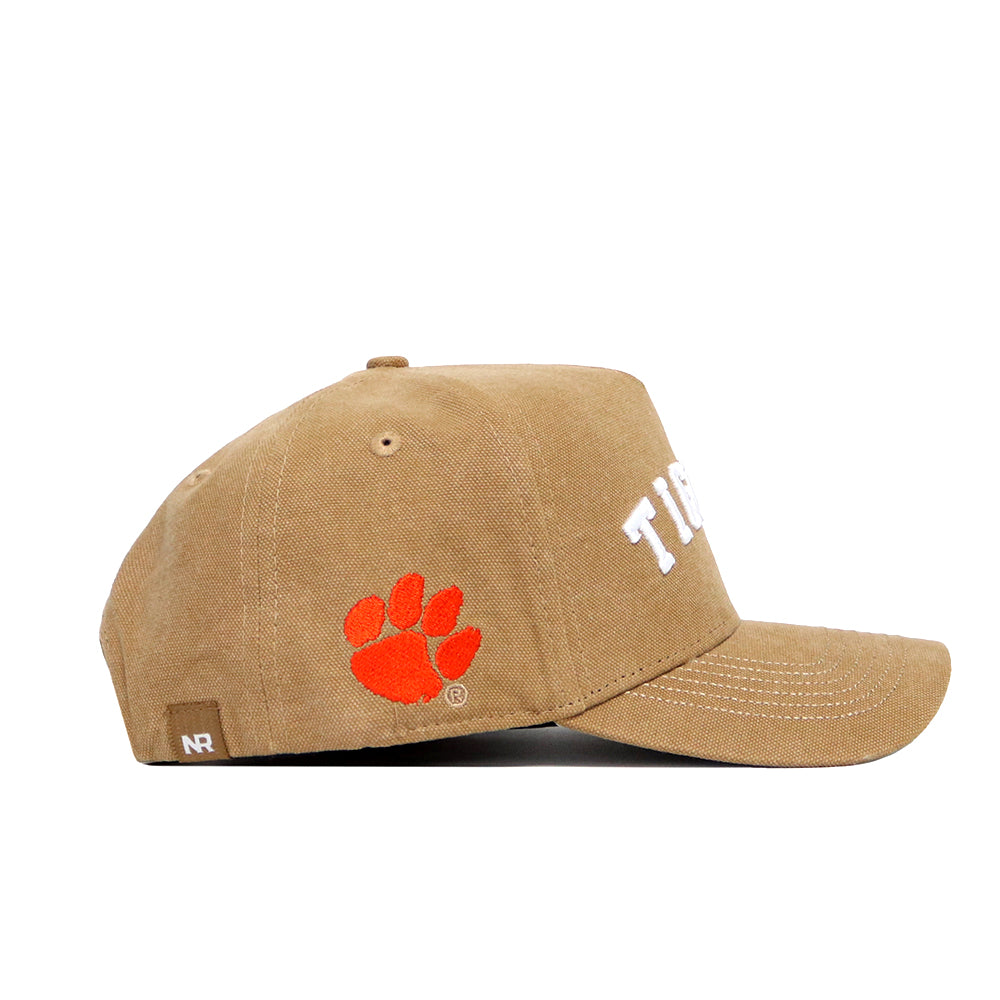 The No Rivals Clemson Rustic Hat is a tan cotton canvas snapback with white stitching, an orange paw print logo on the side, and "TIGERS" in white on the front for classic, adjustable style. Officially licensed.