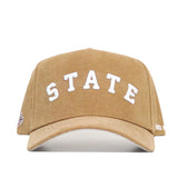 The Mississippi State Rustic Hat by No Rivals is a tan cotton canvas cap with "STATE" in bold white embroidery on the front and an adjustable snapback closure.