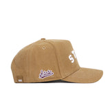 The Mississippi State Rustic Hat by No Rivals is a tan cotton canvas baseball cap with white stitched front lettering, a maroon State logo patch near the back, white-stitched brim, and an adjustable snap back closure.