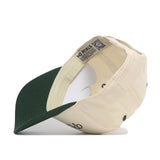 The Play Golf Hat – Classic Green by No Rivals is shown upside down, revealing interior labels, stitching, an embroidered logo, and “NO RIVALS” printed on the inner sweatband.