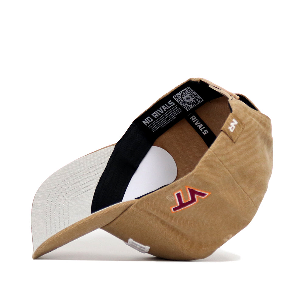 The Virginia Tech Rustic Hat by No Rivals is a tan cotton canvas snapback cap with a curved light gray brim, red and white side logo embroidery, and "NO RIVALS" text on the black inner band. Shown displaying the interior and underside of the brim.