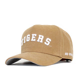 The LSU Rustic Hat by No Rivals is a tan cotton canvas snapback with "TIGERS" embroidered in white on the front and "NO RIV" on the brim's side, shown angled to highlight its structured fit from both front and side views.