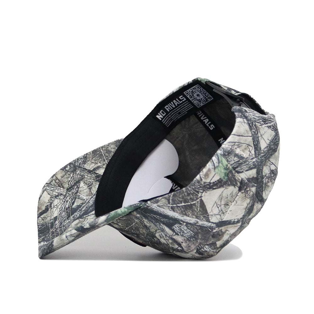The Georgia Outland Hat by No Rivals is a snapback with a black brim, interior label reading NO RIVALS, and a nature-inspired camo pattern in gray, brown, and green tones.