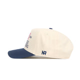 The No Rivals Tennessee Vols 250th Americana Hat is a white snapback with a navy bill, featuring an embroidered front logo and NR initials on the side, displayed here in a side profile view.