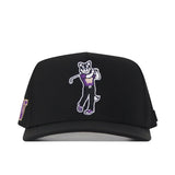 Introducing the Washington Huskies Golf Hat - Black by No Rivals: This black snapback baseball cap features an embroidered cartoon husky mascot in a purple shirt and black pants holding a golf club. The left side showcases an officially licensed purple and gold “W,” while the front boasts a striking embroidered logo.