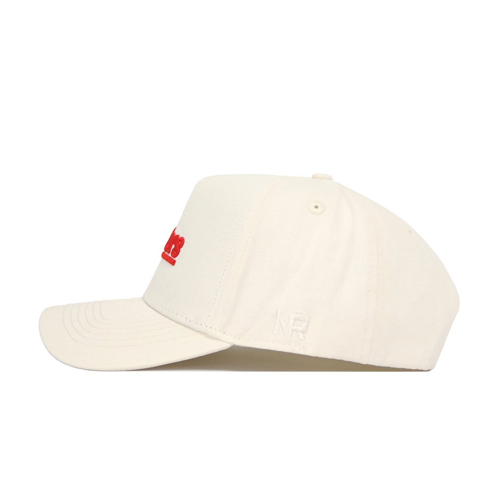 The Nebraska Sideline Hat by No Rivals features a cream snapback design with red embroidered front text and a white NR monogram on the side, crafted from premium cotton for a structured fit.
