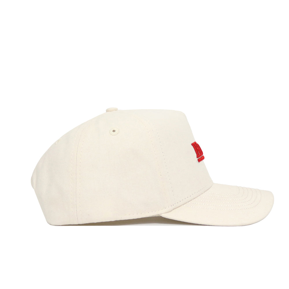 The No Rivals Nebraska Sideline Hat is a cream-colored structured-fit cap with a curved brim and partially visible red embroidery on the front. Made from high-quality cotton, this stylish snapback hat offers lasting comfort and durability.