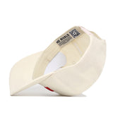 A cream-colored Nebraska Sideline Hat by No Rivals, turned inside out to display its black NO RIVALS label, QR code, and precise brim stitching—a structured snap back cap made from premium cotton.