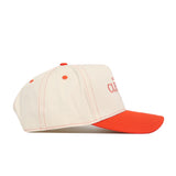 The Clemson Vintage Hat by No Rivals is a cream snapback baseball cap with an orange brim and stitching, shown from the side. The front features partially visible embroidered text—ideal for your gameday look.