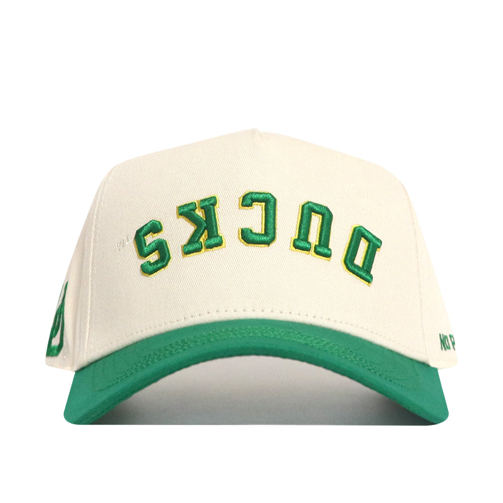 The No Rivals Upside Down Ducks Hat - Oregon - Classic is a white structured snapback with a green brim, featuring “DUCKS” embroidered upside down in green and yellow on the front.