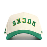 The No Rivals Upside Down Ducks Hat - Oregon - Classic is a white structured snapback with a green brim, featuring “DUCKS” embroidered upside down in green and yellow on the front.