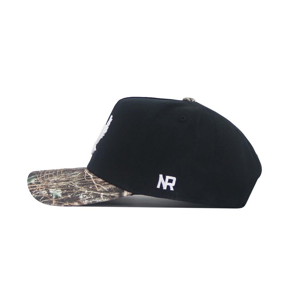 The No Rivals EWU Camo Hat - Trailblazer Edition is a black snapback with a structured fit, showcasing a camo-patterned brim and white embroidered “NR” lettering on the side.