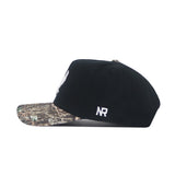 The No Rivals EWU Camo Hat - Trailblazer Edition is a black snapback with a structured fit, showcasing a camo-patterned brim and white embroidered “NR” lettering on the side.