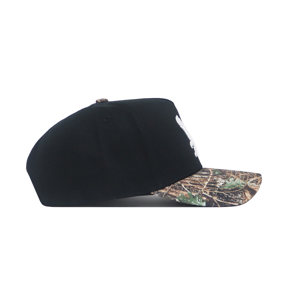 The No Rivals EWU Camo Hat - Trailblazer Edition is a black snapback with a structured fit and a camo-patterned flat brim, displayed from the side on a white background.