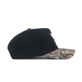 The No Rivals EWU Camo Hat - Trailblazer Edition is a black snapback with a structured fit and a camo-patterned flat brim, displayed from the side on a white background.