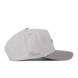 Introducing the NDSU Graphite Hat by No Rivals: this sleek snapback features a light gray crown with a slightly darker graphite brim. The word “Bison” is thoughtfully embroidered in cursive near the back left side, accenting the subtle, complementary logo design. Photographed in side profile against a clean white background, this stylish accessory is perfect for elevating your next gameday fit.