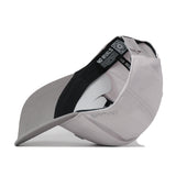 The NDSU Graphite Hat by No Rivals is a light gray snapback, shown inside out to reveal its black and white inner lining, crisp white sweatband, and an interior label that reads “NO RIVALS”—the perfect finishing touch for your gameday outfit.