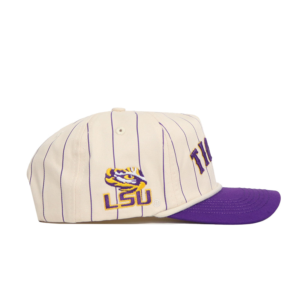 The No Rivals LSU Walk Off Hat is a cream cotton snapback with purple pinstripes, a purple bill, an embroidered LSU logo with tiger face on the side, and partially visible "TIGERS" text on the front. Unstructured fit for comfort.