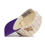 The No Rivals LSU Walk Off Hat features a cream color with purple pinstripes, a purple brim, and an embroidered LSU logo. Made from cotton with an unstructured fit for comfort, its inner band is printed with "NO RIVALS.