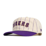 The LSU Walk Off Hat by No Rivals features a cream snapback design with thin purple pinstripes, TIGERS embroidered in purple and gold on the front, a purple brim, and an unstructured fit for casual comfort.