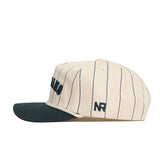 The Michigan State Walk Off Hat by No Rivals is a cream cotton hat with thin navy stripes, a dark green brim, "NR" embroidered above the ear, and an adjustable snapback closure for a perfect fit.