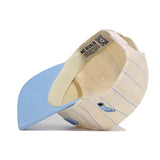 The North Carolina Walk Off Hat by No Rivals is a pastel yellow and blue snapback with light blue pinstripes, shown upside down to display its inside lining and branding. Made from high quality cotton, it features an unstructured fit and solid light blue brim.