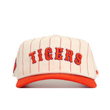 The Clemson Walk Off Hat by No Rivals features cream cotton fabric with thin red vertical stripes, "TIGERS" in bold orange and red letters on the front, an orange brim, and an officially licensed snapback design.