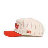 The Clemson Walk Off Hat by No Rivals features a cream snapback design with thin red stripes, an orange brim, and embroidered red NR letters on the side. Made from quality cotton, it offers an unstructured fit for casual comfort.
