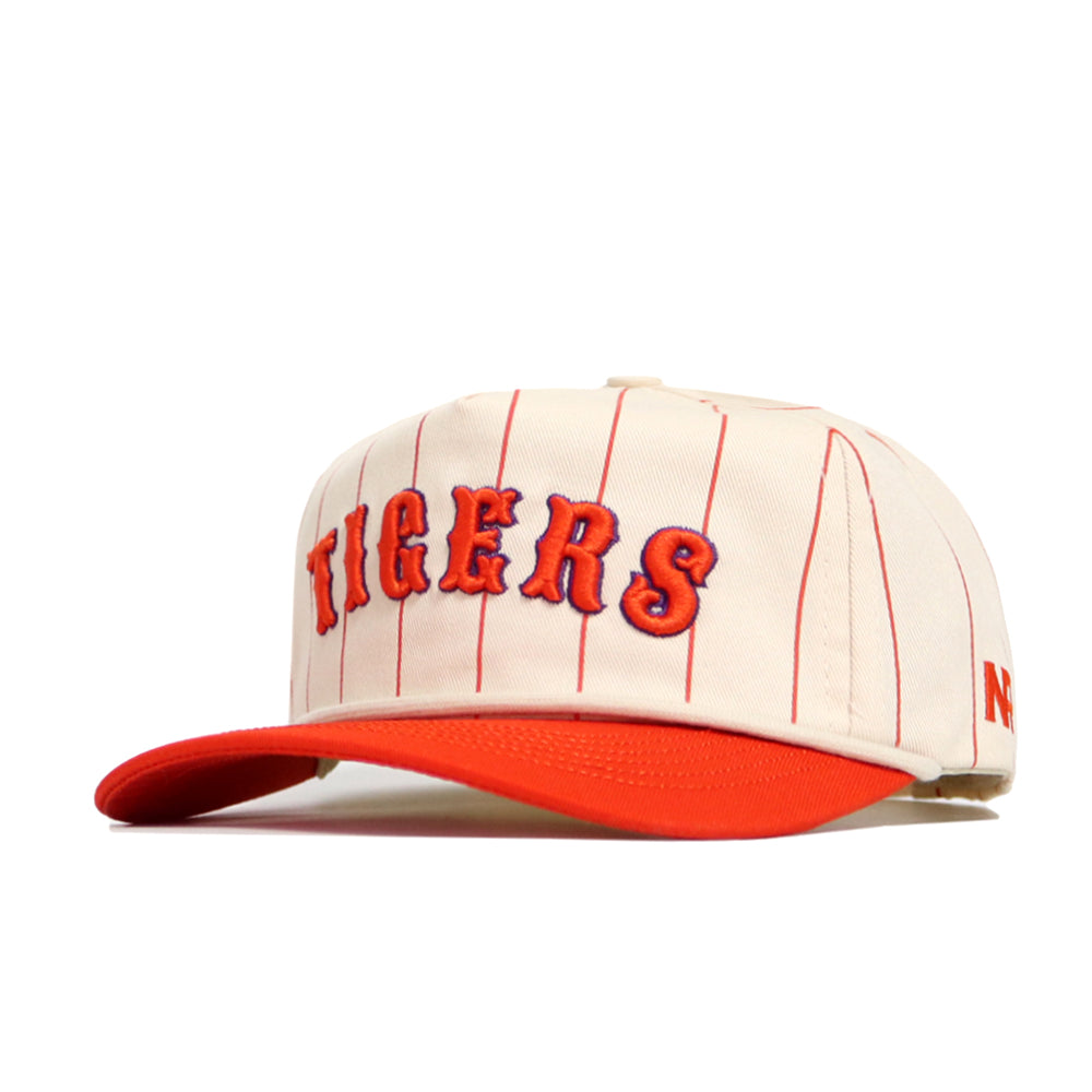The Clemson Walk Off Hat by No Rivals features a cream base with thin red stripes, orange brim, and bold orange and blue TIGERS embroidery. This unstructured snapback is made from premium cotton for all-day comfort.