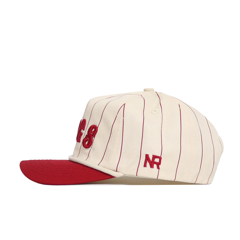The Arkansas Walk Off Hat by No Rivals is a cream cotton cap with thin red vertical stripes, a solid red brim, and embroidered NR letters on the side for a classic style.