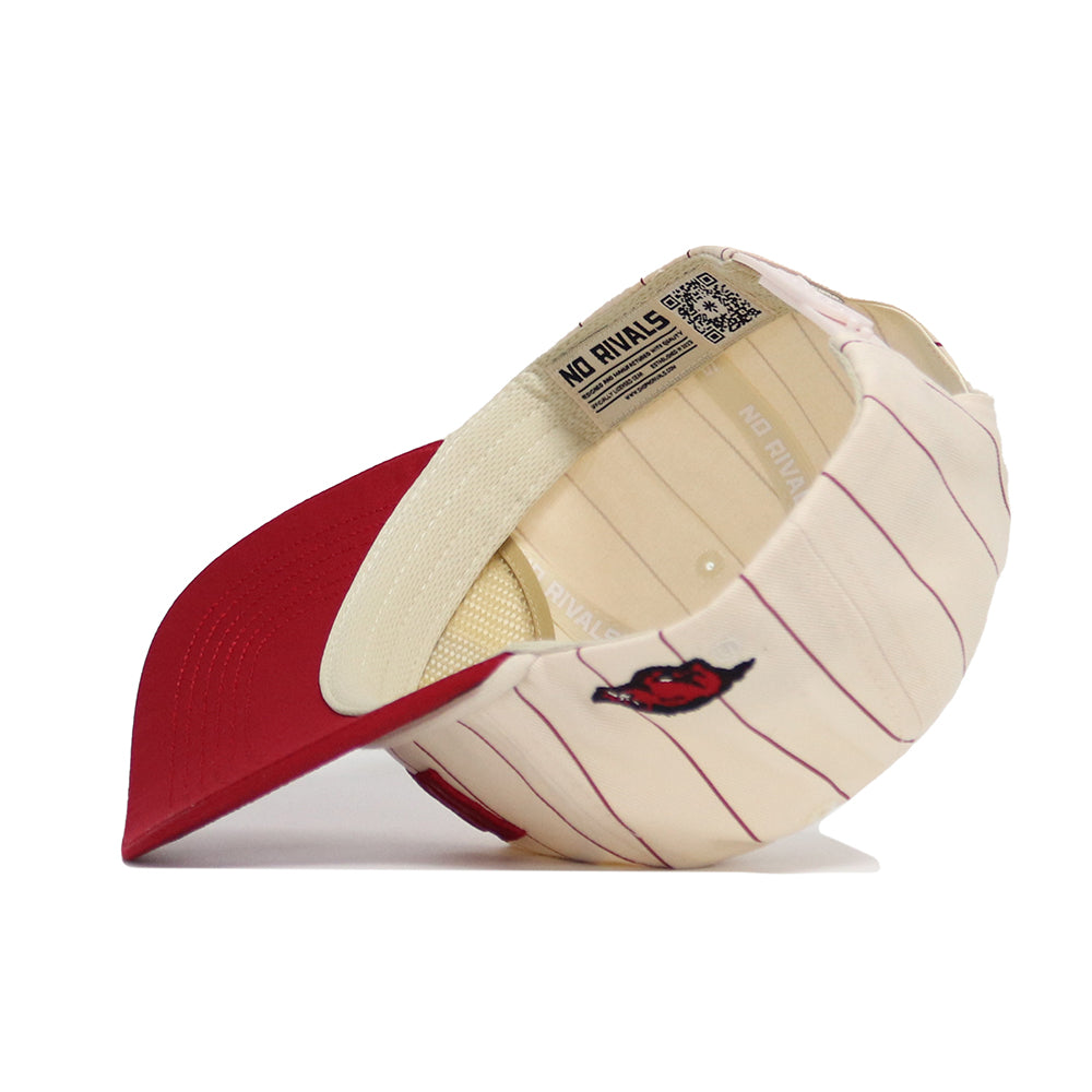 The Arkansas Walk Off Hat by No Rivals is a cream adjustable cotton cap with thin red stripes, a red brim, and a small red devil logo on the side. It features a beige sweatband and a No Rivals label inside near the back opening.