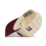 The No Rivals Mississippi State Walk Off Hat is an unstructured cream cap with maroon pinstripes and bill, shown flipped to reveal the interior. Made of premium cotton, it features an embroidered MS logo on the side.