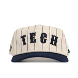 The No Rivals Georgia Tech Walk Off Hat is a cream cotton baseball cap with thin navy pinstripes, “TECH” in bold raised navy letters, a solid navy brim, and an adjustable snap back for comfort.