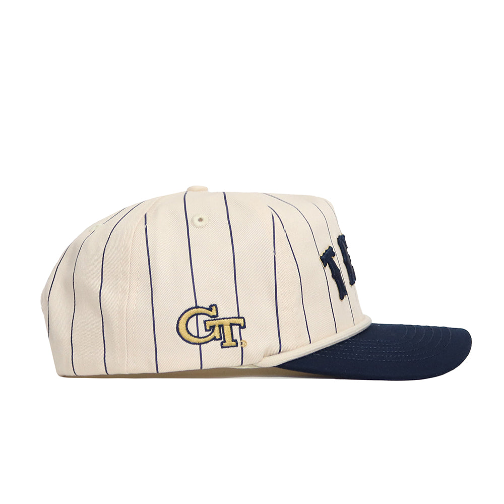The No Rivals Georgia Tech Walk Off Hat is a cream-colored cap with thin navy pinstripes, a navy brim, and GT embroidered in navy and gold on the side. Made of high-quality cotton with an adjustable snapback. Officially licensed.