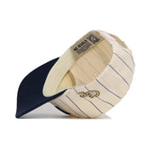 The Georgia Tech Walk Off Hat by No Rivals is a cream baseball cap with thin navy stripes, a navy brim, tan interior, an embroidered front logo, and a “NO RIVALS” label. Made from high quality cotton.