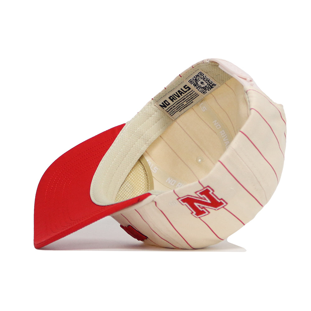 The Nebraska Walk Off Hat by No Rivals features a cream cotton build with red pinstripes, a red brim, and a bold N logo on the front. This adjustable cap includes "NO RIVALS" printed on the sweatband for extra style.