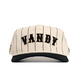 The Vanderbilt Walk Off Hat by No Rivals features cream cotton fabric with thin black pinstripes, "VANDY" in bold black letters, an unstructured fit, black brim, and snapback closure for a laid-back look.