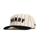 The Vanderbilt Walk Off Hat by No Rivals features a cream cotton snapback with thin black stripes, a black bill, and bold black "VANDY" lettering on the front for an unstructured, stylish fit.